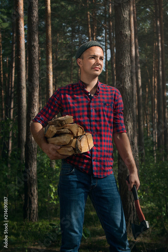 Tableau sur toile Young man chopping wood in the forest