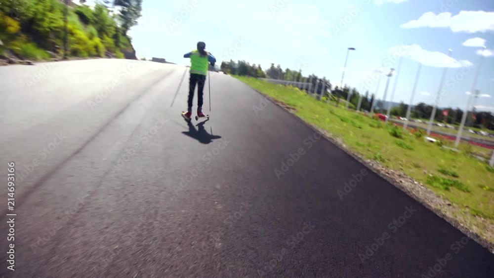 Roller Skiing Training On Hill Near The Holmenkollen Ski Jump. Children In Norway Learn This Sport At Young Age On Preparation For Cross-Country Skiing In The Winter. Roller Skiing Training On Hill Near The Holmenkollen Ski Jump. Children In Norway Learn This Sport At Young Age On Preparation For Cross-Country Skiing In The Winter.