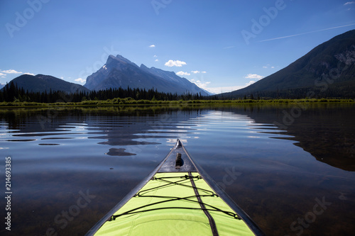 Kayaking in a beautiful lake surrounded by the Canadian Mountain Landscape. Taken in Banff, Alberta, Canada.