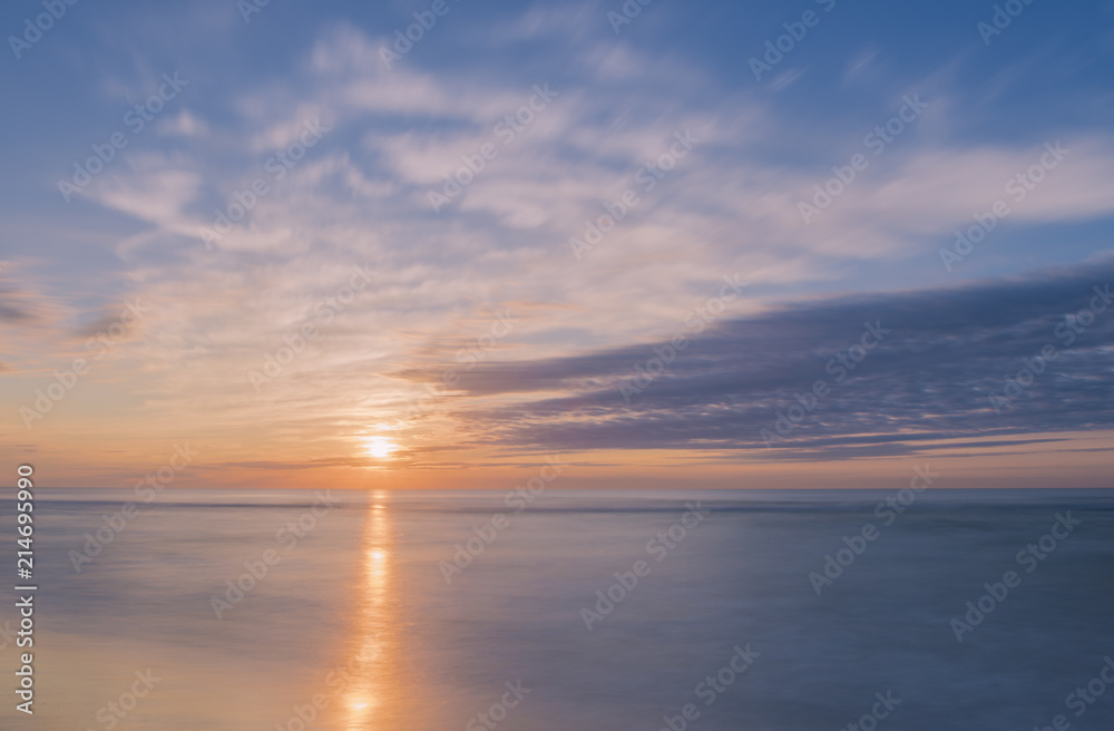 Tranquil sunrise over Avon By The Sea beach in New Jersey shot using slow shutter speed
