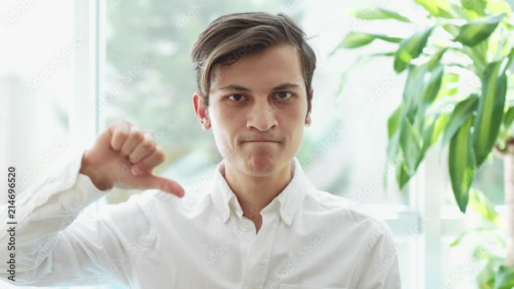 Reaction of Loss,Thumbs Down, Unsatisfied Young Man Reaction of Loss,Thumbs Down, Unsatisfied Young Man
