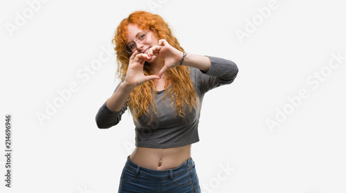 Young redhead woman smiling in love showing heart symbol and shape with hands. Romantic concept.