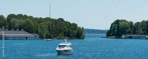 White power boat and boathouses on Lake Charlevoix in Upper Michigan photo