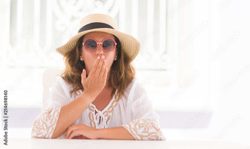 Middle age brunette woman sitting at the table cover mouth with hand shocked with shame for mistake, expression of fear, scared in silence, secret concept