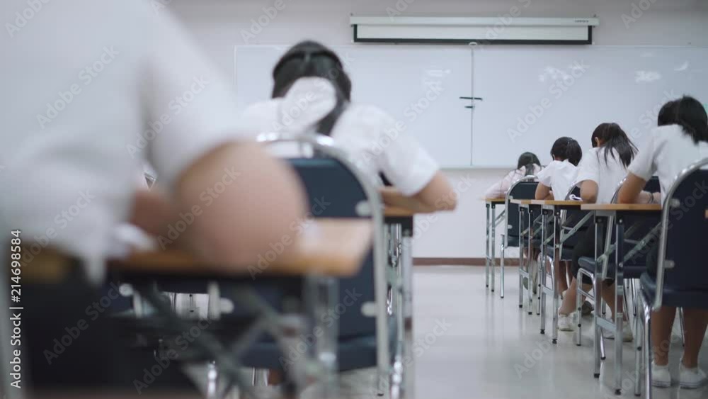 Asian students taking an exam in class room Asian students taking an exam in class room