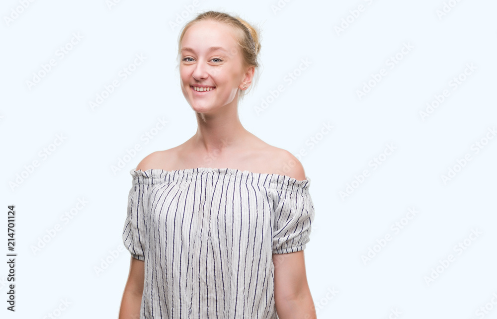 Blonde teenager woman wearing a bun with a happy face standing and smiling with a confident smile showing teeth Blonde teenager woman wearing a bun with a happy face standing and smiling with a confident smile showing teeth