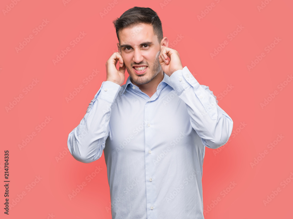 Handsome young businessman covering ears with fingers with annoyed expression for the noise of loud music. Deaf concept. Handsome young businessman covering ears with fingers with annoyed expression for the noise of loud music. Deaf concept.