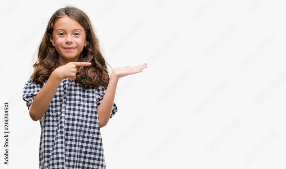 Brunette hispanic girl wearing black and white dress very happy pointing with hand and finger Brunette hispanic girl wearing black and white dress very happy pointing with hand and finger