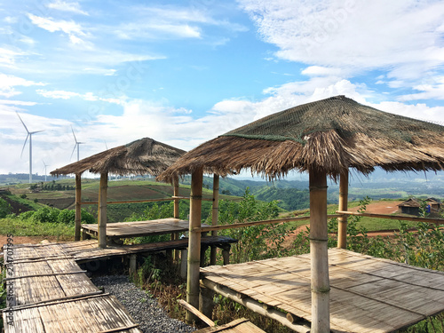 Bamboo shelter over windmill field background