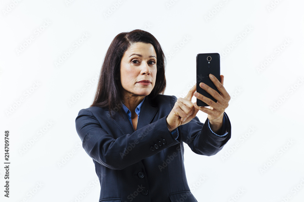 Portrait of business woman pressing on her cell phone and looking at camera , isolated on white studio background Portrait of business woman pressing on her cell phone and looking at camera , isolated on white studio background