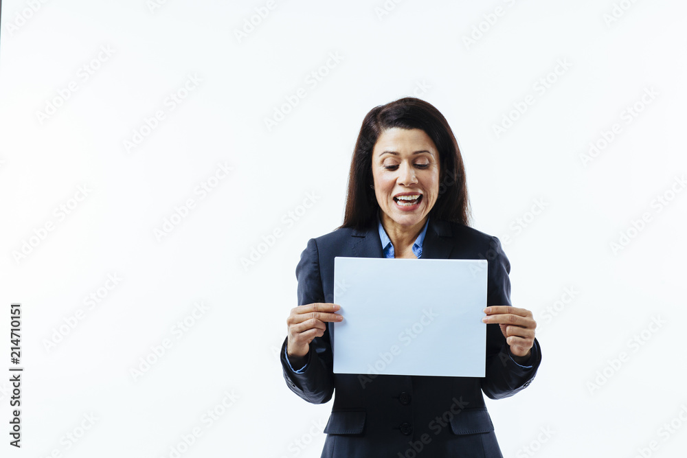 Portrait of an excited woman holding blank sign and looking at it, isolated on white studio background Portrait of an excited woman holding blank sign and looking at it, isolated on white studio background