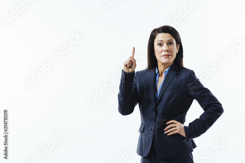 Portrait of smiling business woman pointing up with one finger, isolated on white studio background