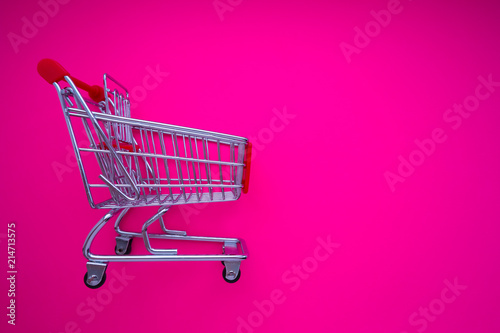 empty shopping cart on magenta background
