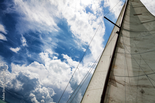 Old sail against the blue sky with clouds, close-uo