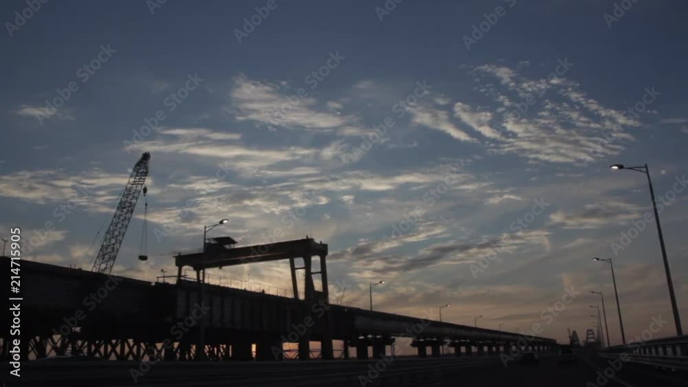 Drive through the Brige under construction with dramatic Clouds and the setting Sun. Sunset Drive through the Brige under construction with dramatic Clouds and the setting Sun. Sunset