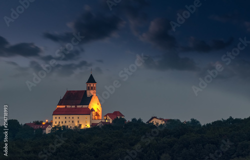 Illuminated Christian Church on hill at dusk, Ptujska Gora, Slovenia photo