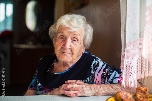 Portrait of an elderly woman sitting at the table. photo