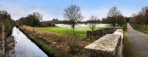 Canvas Print Panoramic view of Cranford Park and river Crane after a mild snowfall in March