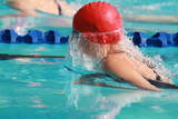 Young Swimmer with Red Cap Swims Breast Stroke 
