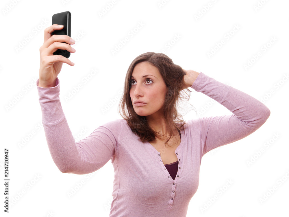 Fototapeta premium young woman making duckface while taking a selfportrait with her smartphone