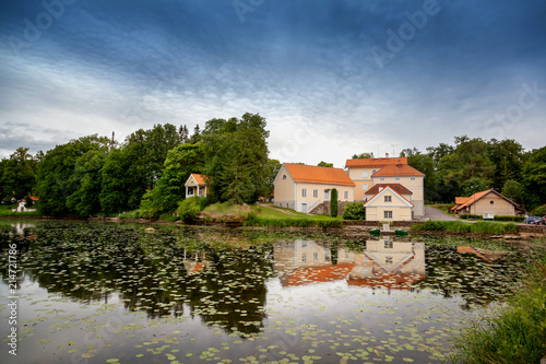 An old manor house Vihula in Estonia, Lahemaa park. Beautiful summer landscape with pond photo