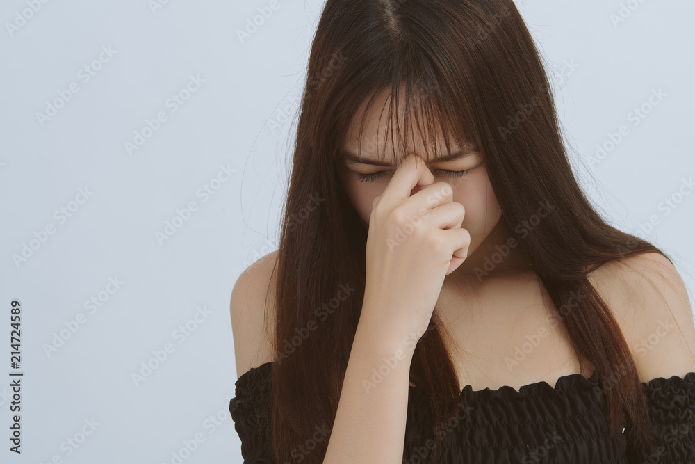 Young asian woman has headache, on a gray background. Business woman serious with her job. Young asian woman has headache, on a gray background. Business woman serious with her job.