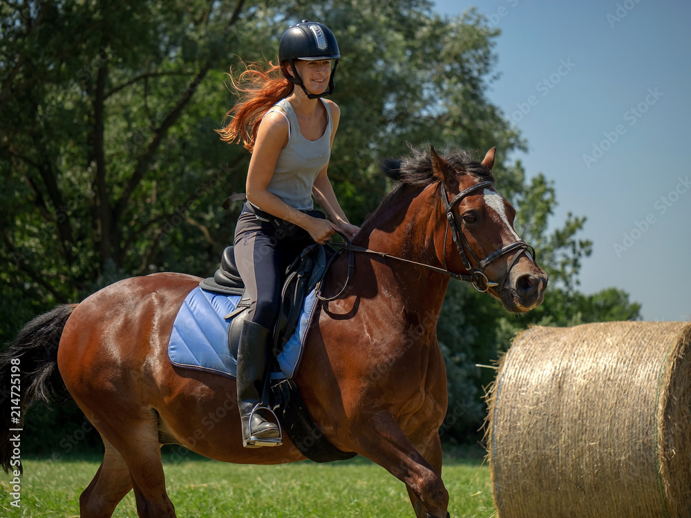 Frau model Rieterin reitet auf Pferd auf Wiese in der Natur bei Sonnenschein im Sommer Frau model Rieterin reitet auf Pferd auf Wiese in der Natur bei Sonnenschein im Sommer
