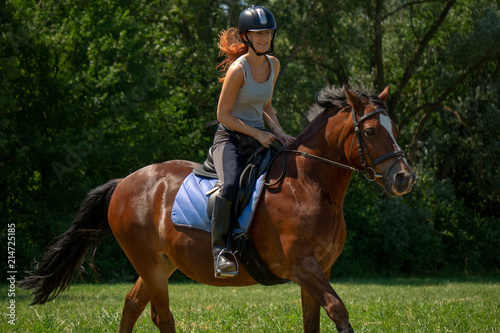 Frau model Rieterin reitet auf Pferd auf Wiese in der Natur bei Sonnenschein im Sommer © gismo2015