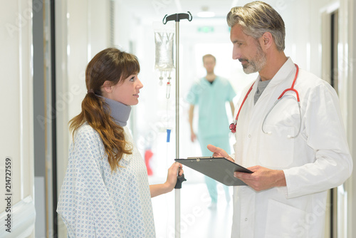 Doctor talking to patient in hospital corridor