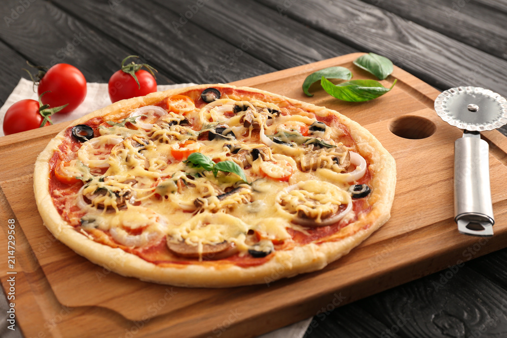 Cutting board with tasty pizza on wooden table