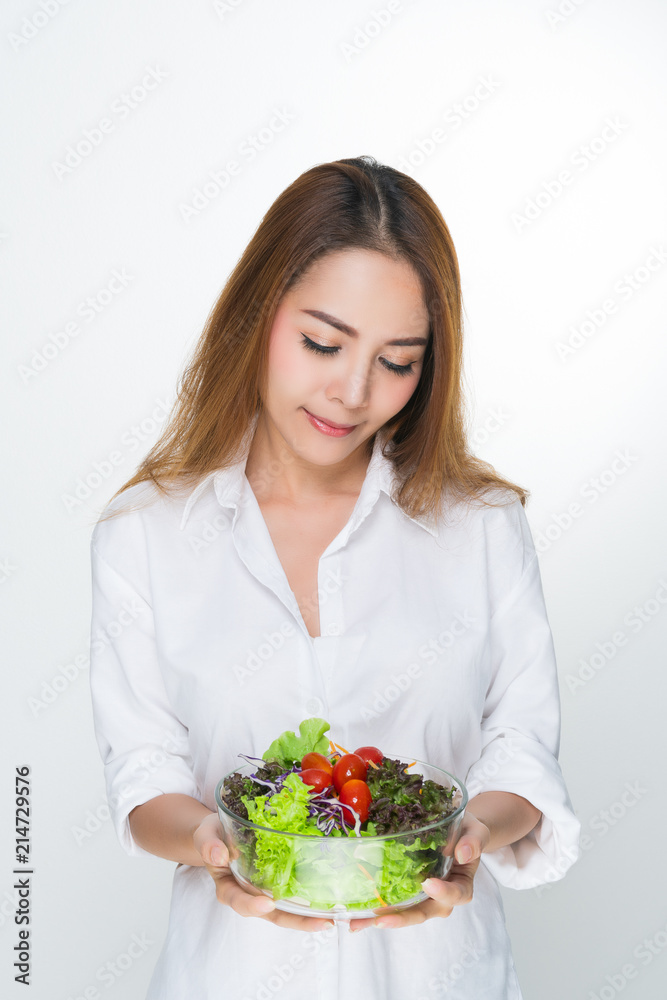 Woman wearing a white bowl holding a salad bowl. Woman wearing a white bowl holding a salad bowl.
