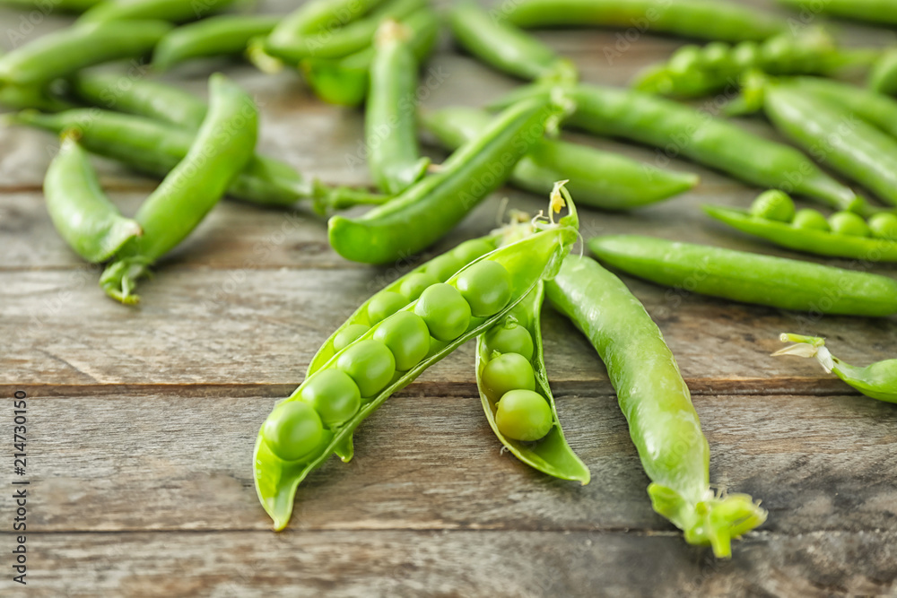 Delicious fresh green peas on wooden background Delicious fresh green peas on wooden background