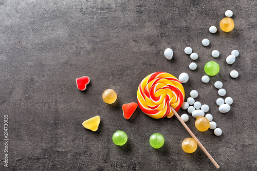 Colorful candies with lollipop on grey background