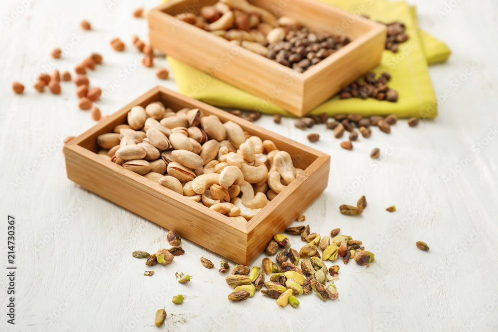 Box with different nuts on white wooden background Box with different nuts on white wooden background