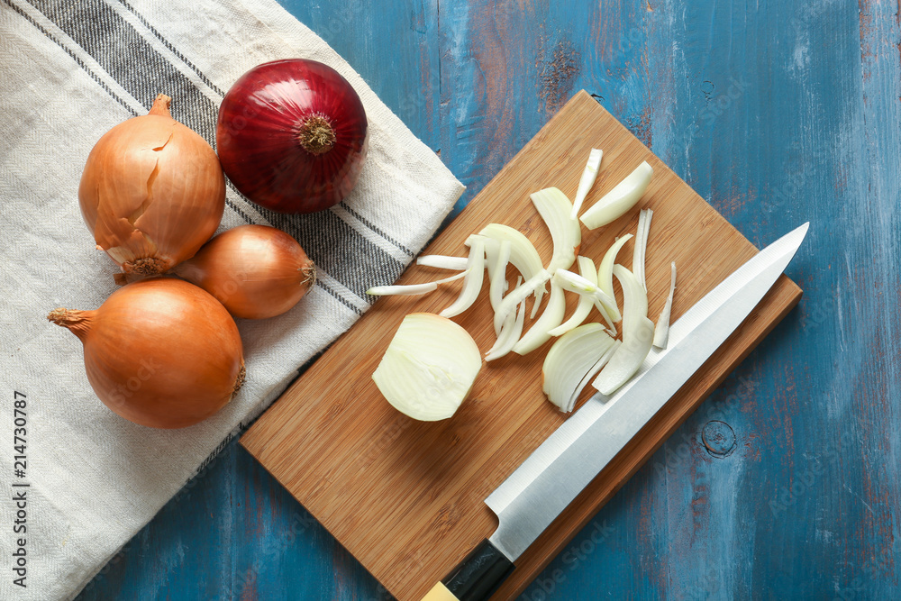 Wooden board with sliced and whole onion on table Wooden board with sliced and whole onion on table