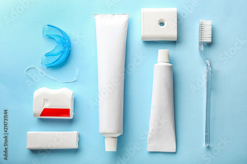 Toothbrush, mouth guard, paste and dental floss on color background