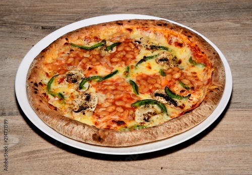 Whole round pizza topped with cheese, tomato, green peppers, mushrooms and baked beans.