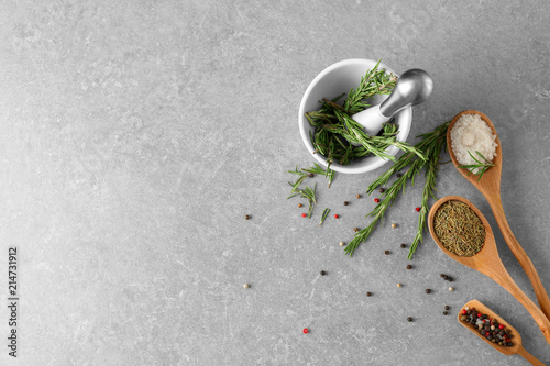 Composition with fresh rosemary and dried spices on grey background