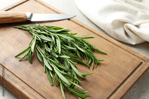 Fresh rosemary with knife on wooden board