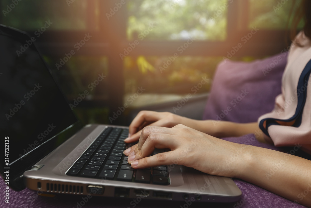 Fototapeta premium Closeup of businesswoman hands on laptop at office desk. woman using laptop for searching web or browsing information, home office concept