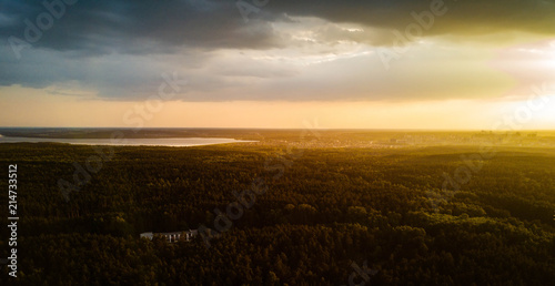 Aerial drone view of residential area with huge city forest, capital of South Ural in sunny evening after rain, park of culture and recreation on the foreground, Russia