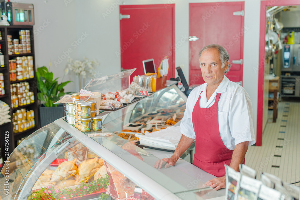 Proud butcher stood by his display Proud butcher stood by his display