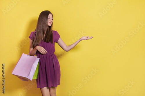 beautiful casual girl with shopping bag presenting blank space