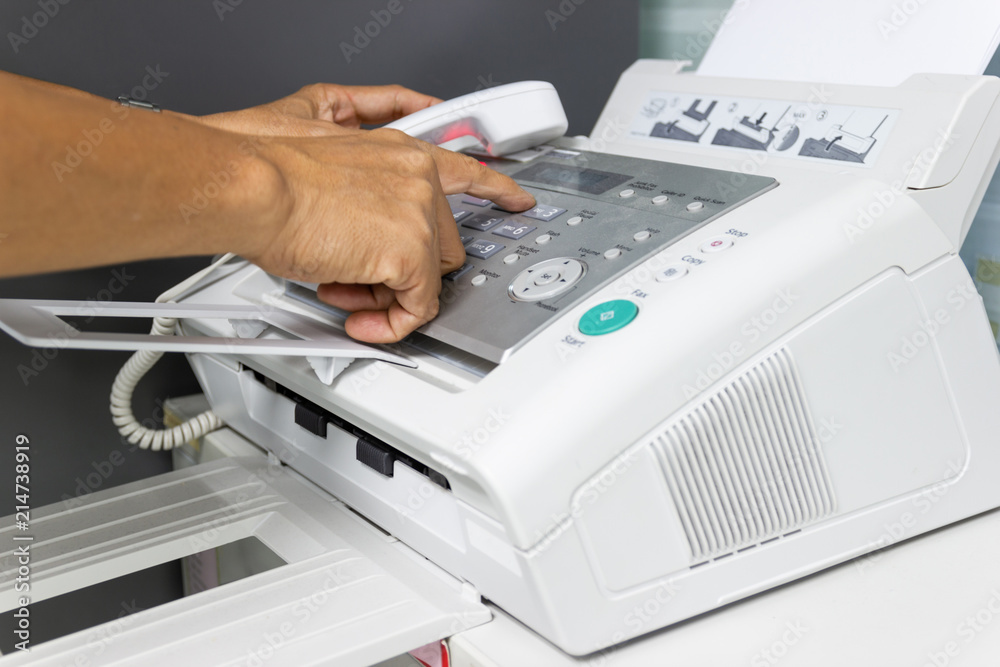 hand man are using a fax machine in the office. Business concept hand man are using a fax machine in the office. Business concept