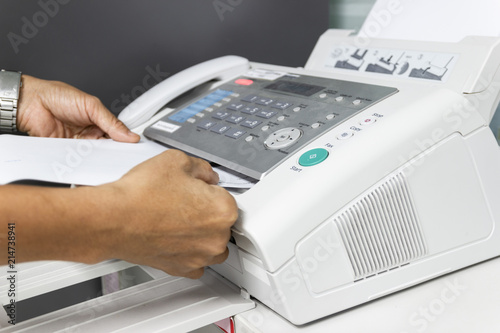 hand man are using a fax machine in the office. Business concept 