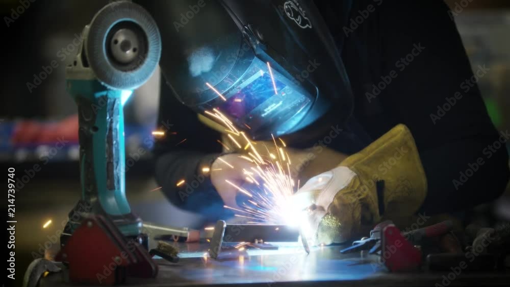 Man Welding Metal in a Workshop with protective mask Slow Motion Man Welding Metal in a Workshop with protective mask Slow Motion