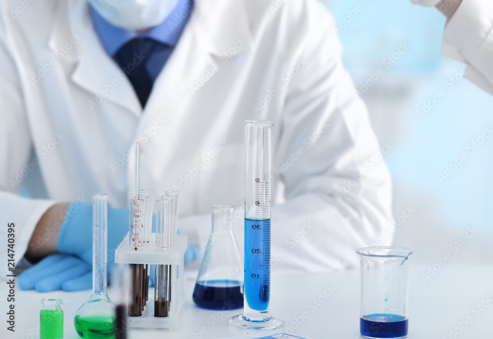 Fototapeta premium Scientist with test glassware in laboratory
