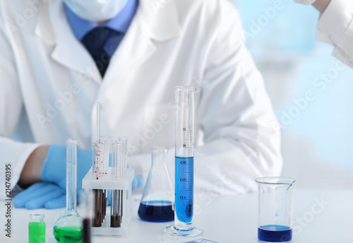 Scientist with test glassware in laboratory