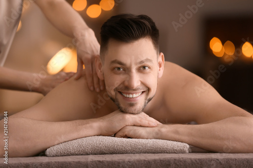 Young man receiving massage at spa salon