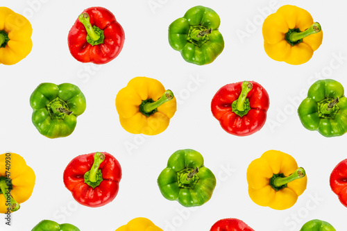 Top view pattern of fresh bright bell peppers on white background. Shot from above of multiple colorful paprika vegetables